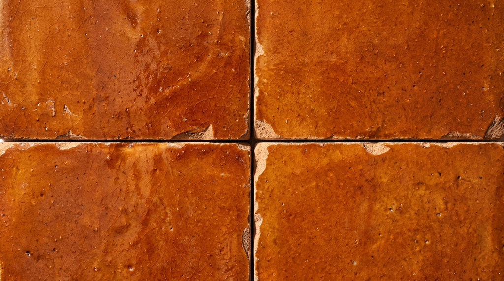 Four orange square tiles with textured surfaces and irregular edges
